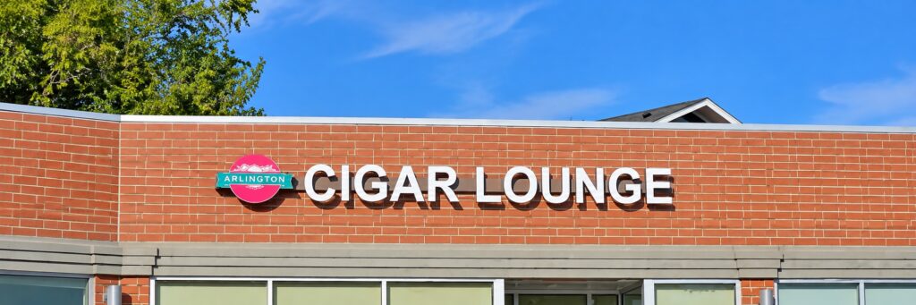 Exterior of Arlington Pipe & Cigar Lounge in Arlington Heights, Illinois, featuring the original red brick facade and distinctive Arlington Pipe and Cigar Lounge storefront signage.