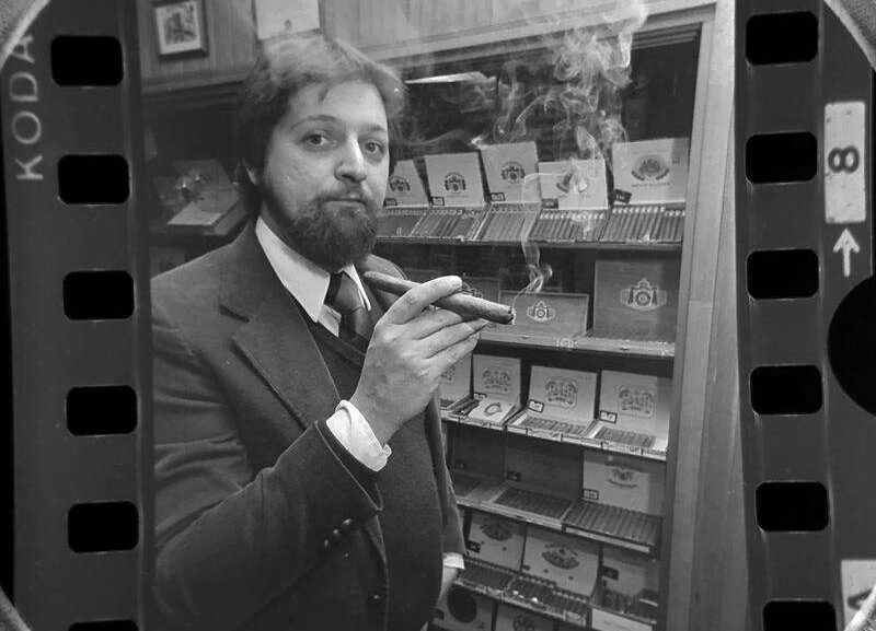 Archival photograph of Hank Pietruszka smoking a cigar inside Arlington Pipe & Cigar in Arlington Heights, Illinois, in February 1981, surrounded by tobacco displays and a Peterson's Pipe sign. Photograph by Barry Jarvinen for the Daily Herald.