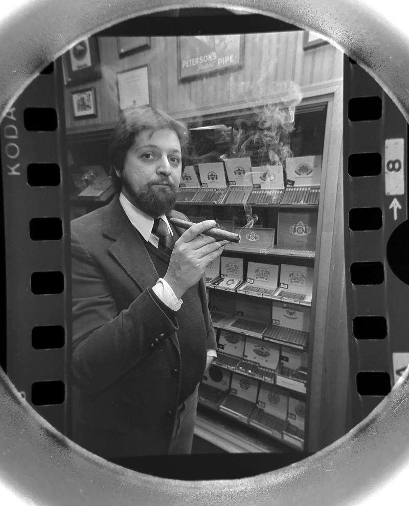 Archival photograph of Hank Pietruszka smoking a cigar inside Arlington Pipe & Cigar in Arlington Heights, Illinois, in February 1981, surrounded by tobacco displays and a Peterson's Pipe sign. Photograph by Barry Jarvinen for the Daily Herald.